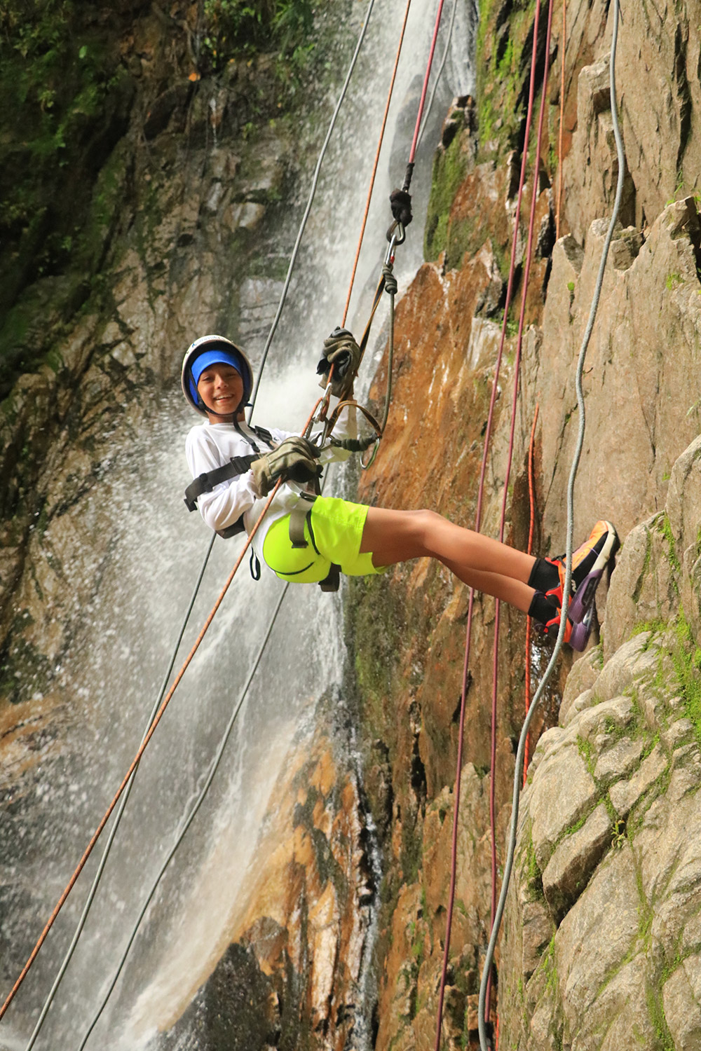 Oliver rappels down steep rocks surrounded by rushing waterfalls in Mexico. August, 2021